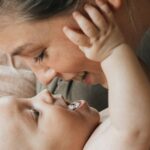A mother lovingly interacts with her baby, capturing an intimate bonding moment.