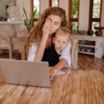 Woman multitasking while working from home with child. Relaxed ambiance.