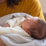 Neugeborenes Baby auf dem Arm